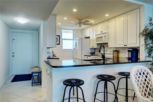 a living room with furniture and a dining table with kitchen view