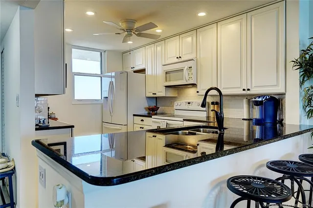 a kitchen with stainless steel appliances white cabinets and a refrigerator