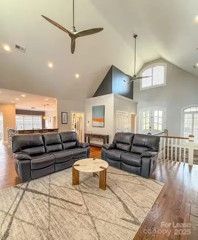 a living room with furniture ceiling fan and a wooden floor