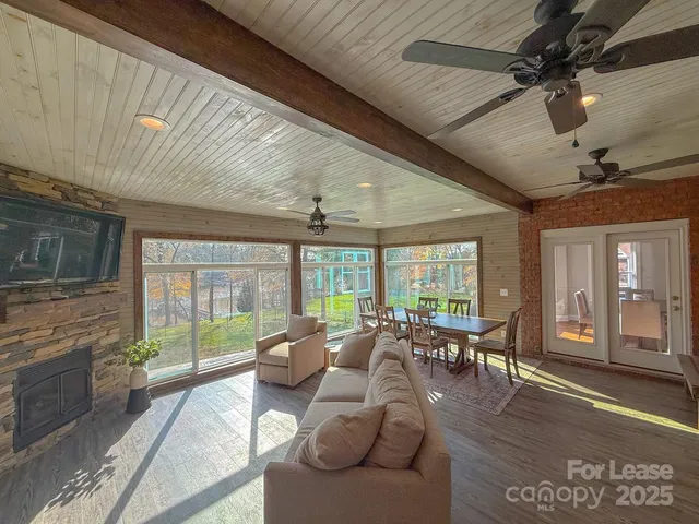 a living room with furniture floor to ceiling window and wooden floor