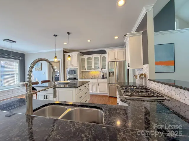 a kitchen with sink and view of living room