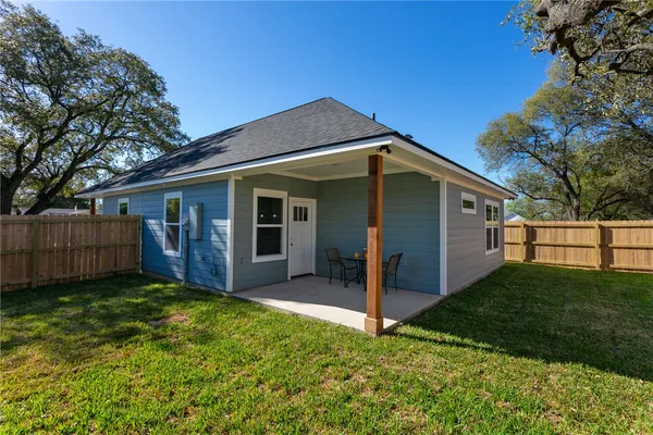 a view of a house with a yard and wooden fence