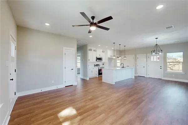 a view of an empty room with window and wooden floor