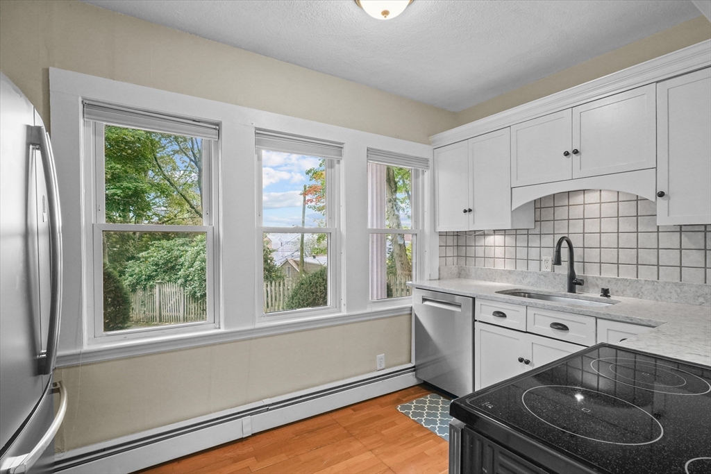 201 Humphrey Street, Unit 2 Marblehead, MA 01945 - Photo 9 of 33 a kitchen with a sink stove and cabinets