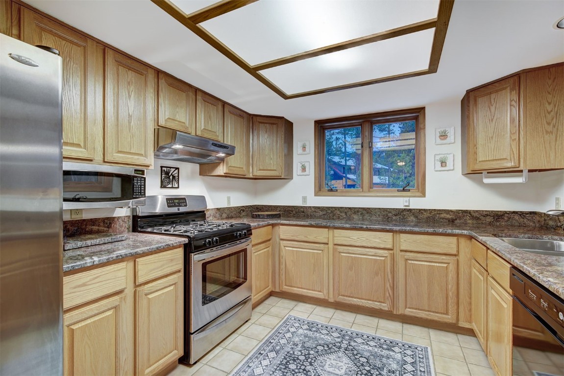 3824 Ski Hill Road Breckenridge, CO 80424 - Photo 15 of 47 a kitchen with stainless steel appliances granite countertop a stove sink and cabinets