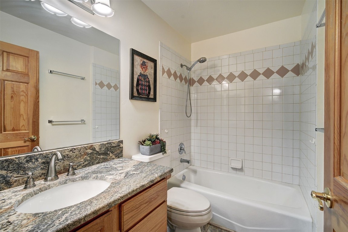 3824 Ski Hill Road Breckenridge, CO 80424 - Photo 24 of 47 a bathroom with a granite countertop sink a toilet a mirror a shower and a bathtub