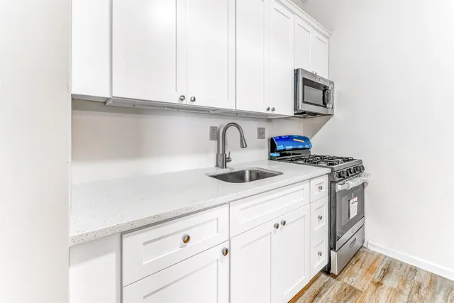 a kitchen with stainless steel appliances granite countertop white cabinets a sink and dishwasher