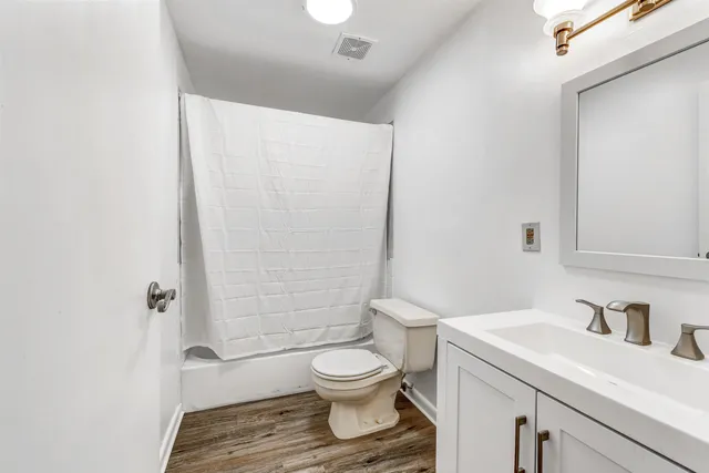 a bathroom with a granite countertop sink a toilet and a shower