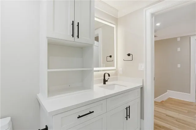 a view of a house with a yard plants and large tree