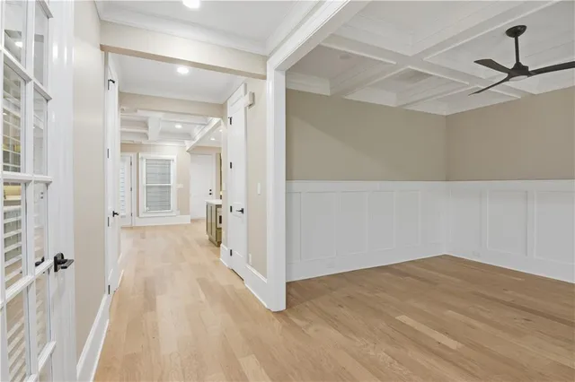 a view of empty room with wooden floor and fan