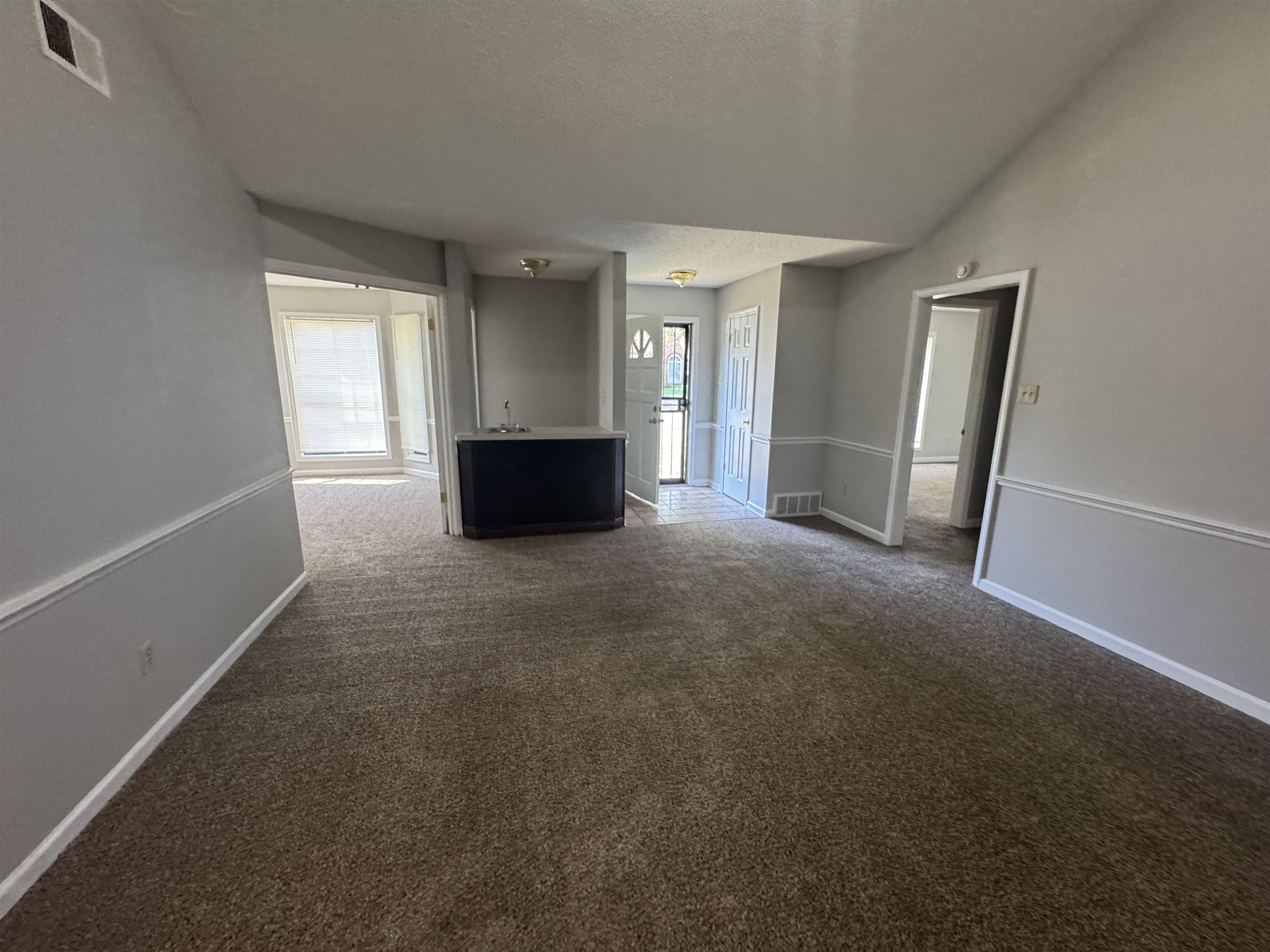 7266 Woodshire Road Memphis, TN 38125 - Photo 13 of 14 Unfurnished living room featuring dark carpet and a textured ceiling