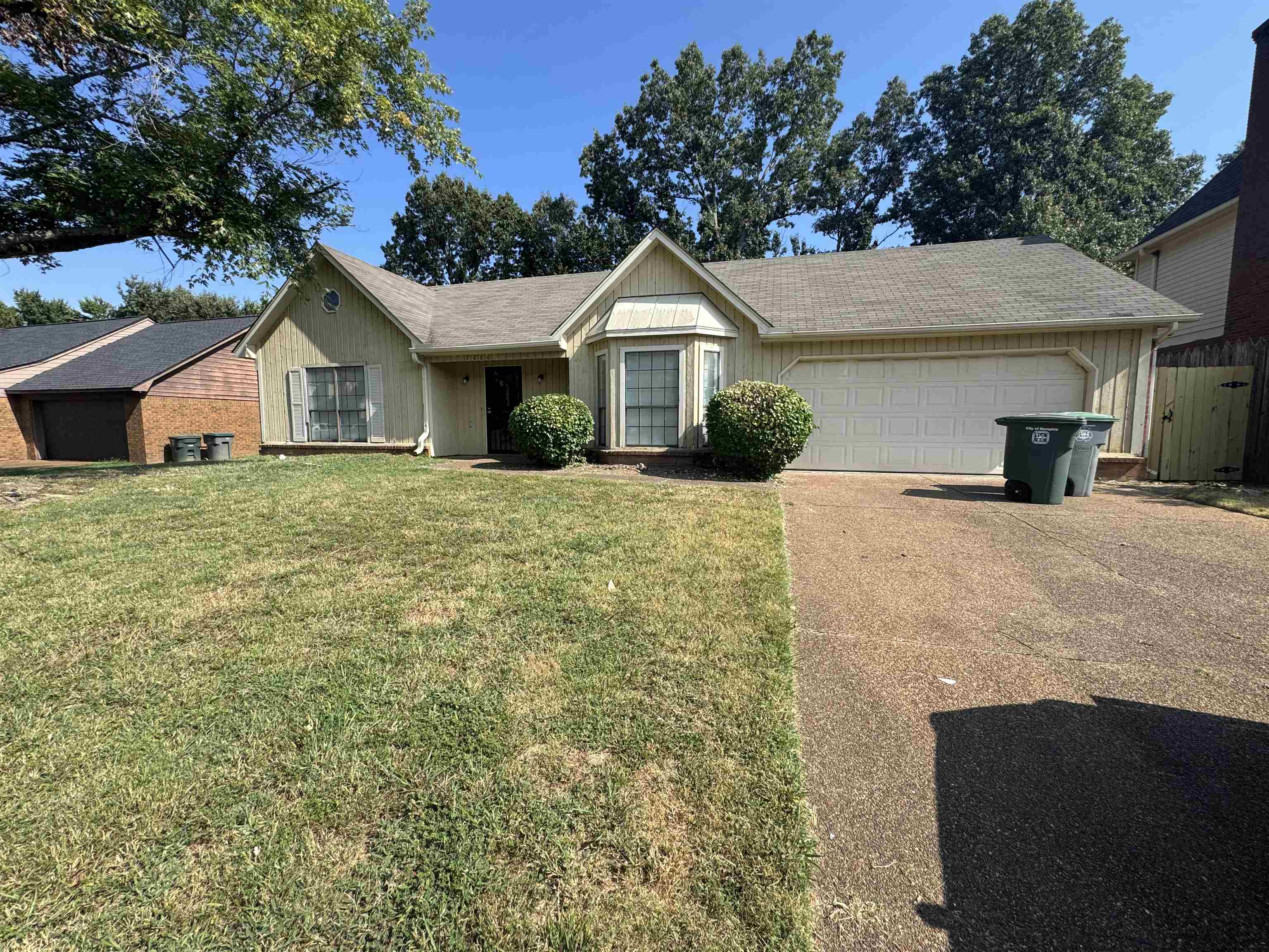7266 Woodshire Road Memphis, TN 38125 - Photo 2 of 14 Ranch-style home featuring concrete driveway, a front yard, a shingled roof, and a garage