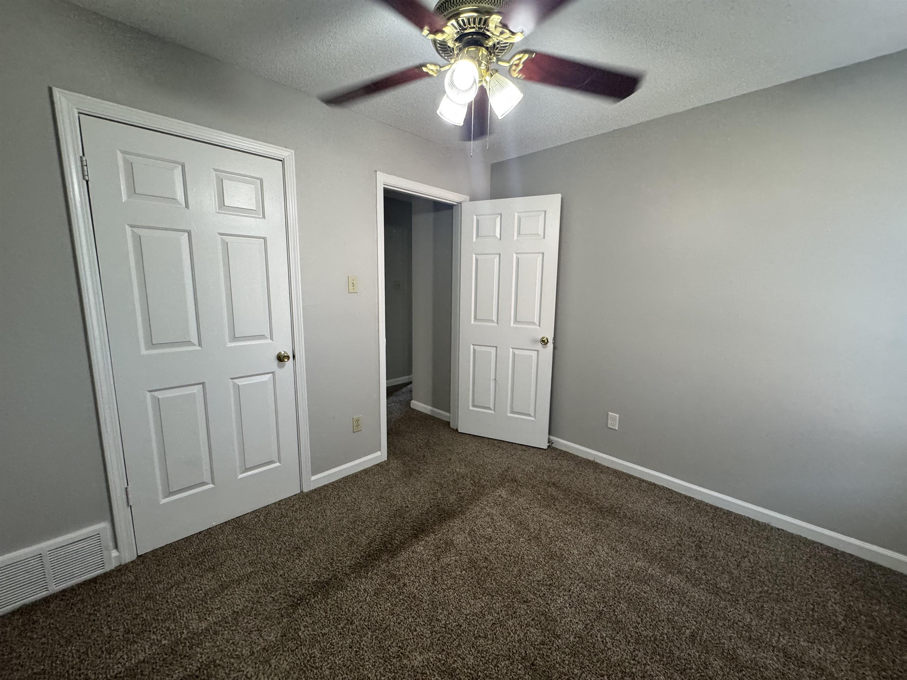 7266 Woodshire Road Memphis, TN 38125 - Photo 8 of 14 Unfurnished bedroom featuring dark colored carpet, a textured ceiling, and a ceiling fan