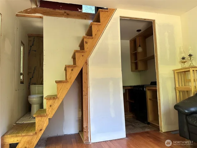 a view of hallway with stairs and wooden floor