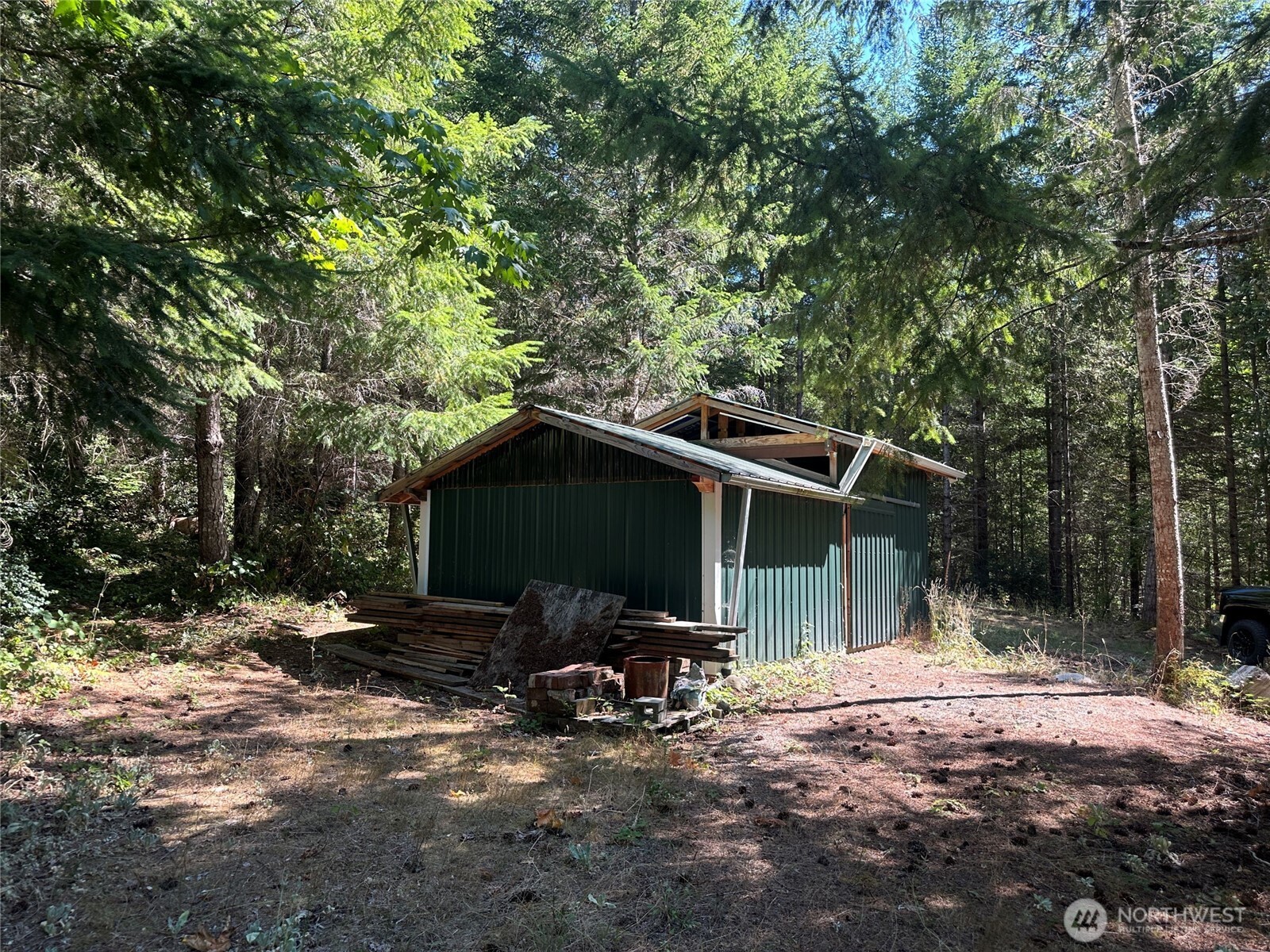 22222-nhn East Quilcene Road Quilcene, WA 98376 - Photo 27 of 39 a backyard of a house with table and chairs under an umbrella