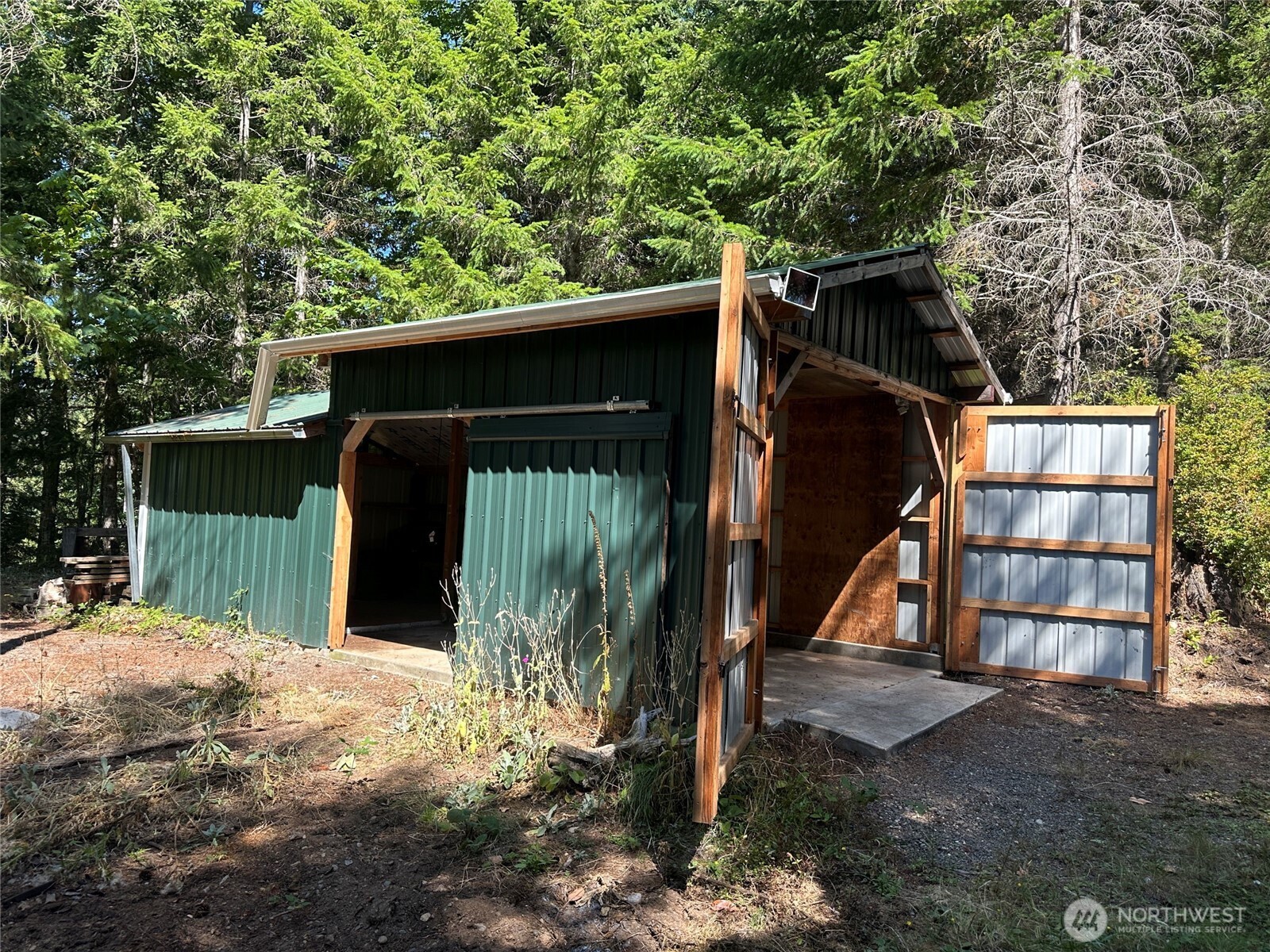 22222-nhn East Quilcene Road Quilcene, WA 98376 - Photo 28 of 39 a view of a wooden house with large trees and wooden fence