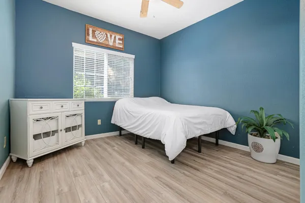 a bedroom with a bed and a potted plant