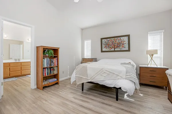 a bed sitting in a bedroom and night stand