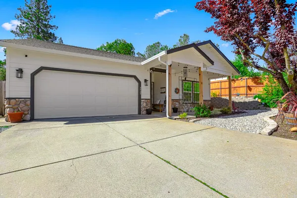 a view of a white house with a large tree