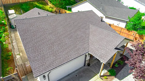 a aerial view of a house with a yard and large trees