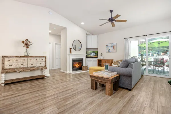a living room with furniture a fireplace and a floor to ceiling window