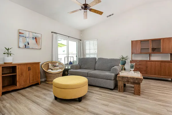 a living room with furniture a window and wooden floor