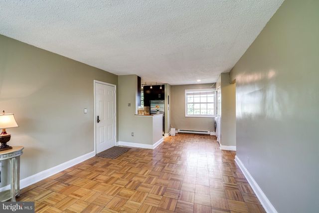 a view of a livingroom with wooden floor and kitchen space