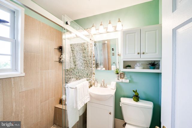 a bathroom with a shower a toilet and a window