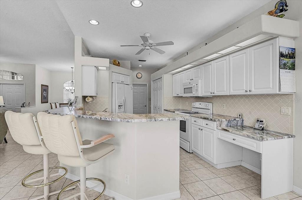 2115 Muskogee Trail Nokomis, FL 34275 - Photo 11 of 39 a large kitchen with kitchen island a white counter space a sink cabinets and appliances