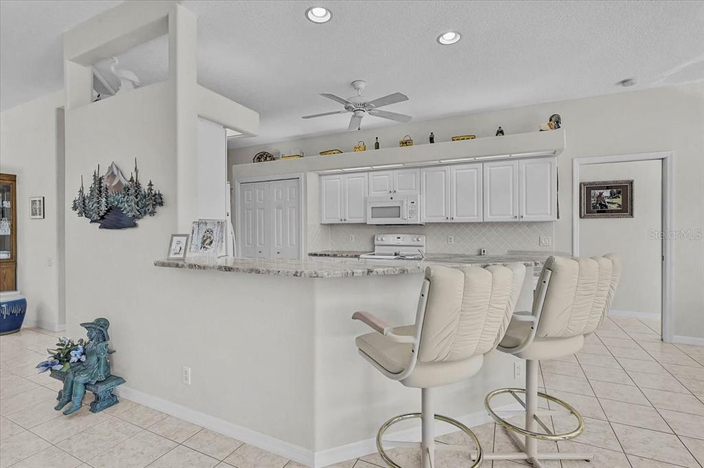 2115 Muskogee Trail Nokomis, FL 34275 - Photo 13 of 39 a kitchen with stainless steel appliances granite countertop a white cabinets and a stove