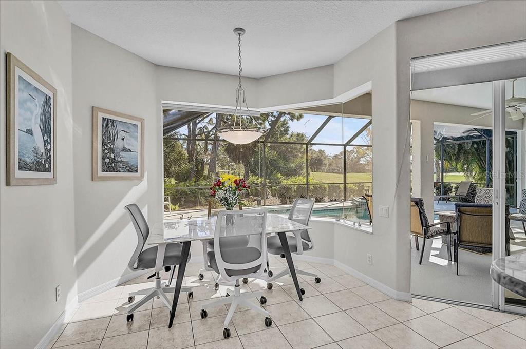 2115 Muskogee Trail Nokomis, FL 34275 - Photo 14 of 39 a view of a dining room with furniture large windows and wooden floor