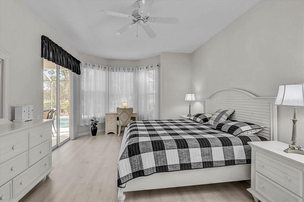 2115 Muskogee Trail Nokomis, FL 34275 - Photo 15 of 39 a bedroom with a large bed and a chandelier