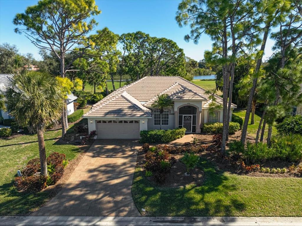 2115 Muskogee Trail Nokomis, FL 34275 - Photo 2 of 39 a front view of a house with a yard and green space