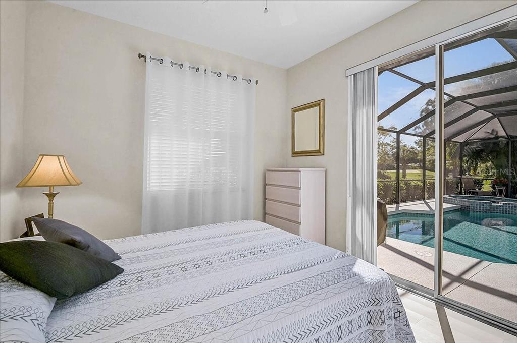 2115 Muskogee Trail Nokomis, FL 34275 - Photo 22 of 39 a bedroom with a bed and a lamp next to a window