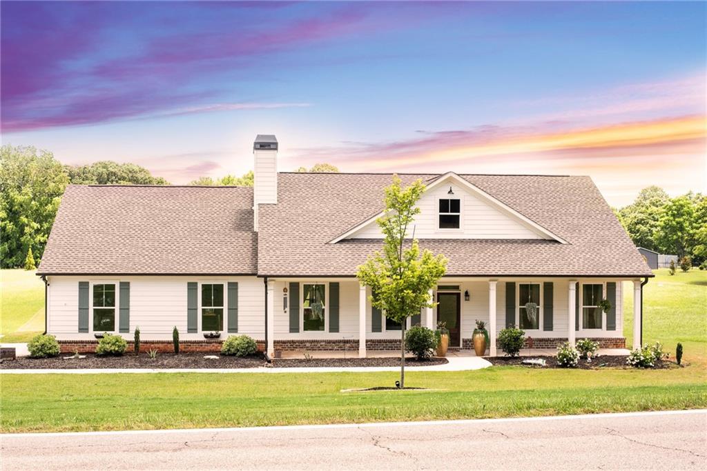 a front view of a house with a yard and potted plants
