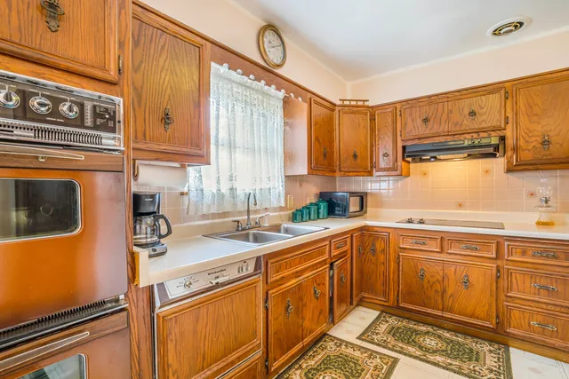 a kitchen with stainless steel appliances a sink a stove and cabinets