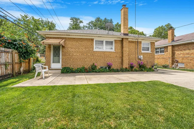 a view of a house with backyard and a tree