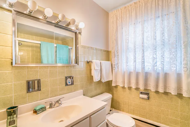 a bathroom with a sink a toilet and mirror