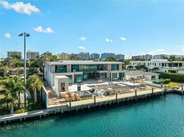 a view of a lake with lawn chairs and a yard