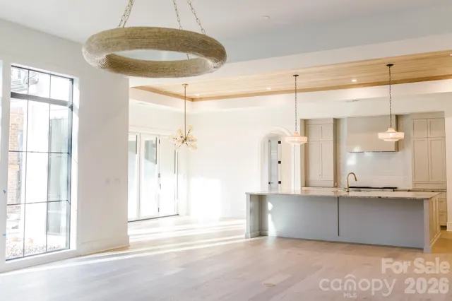 a kitchen with stainless steel appliances kitchen island granite countertop a dining table chairs and a sink