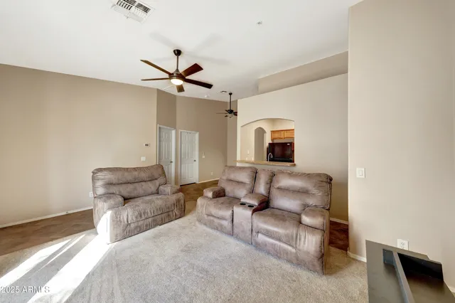 a living room with furniture and a ceiling fan