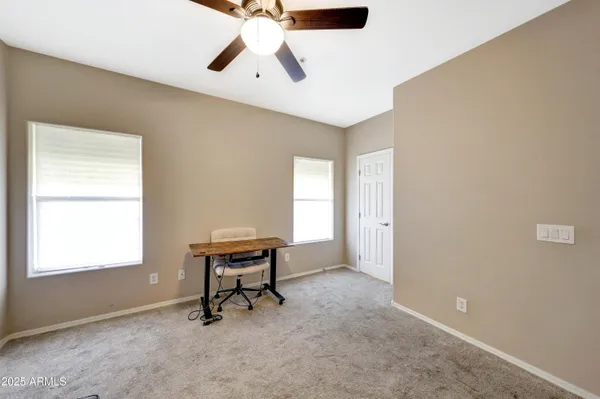 a view of a workspace with furniture and a window