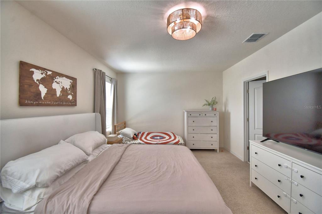 2839 Moulin Road Davenport, FL 33837 - Photo 40 of 75 a bedroom with a bed and a flat tv screen on dresser