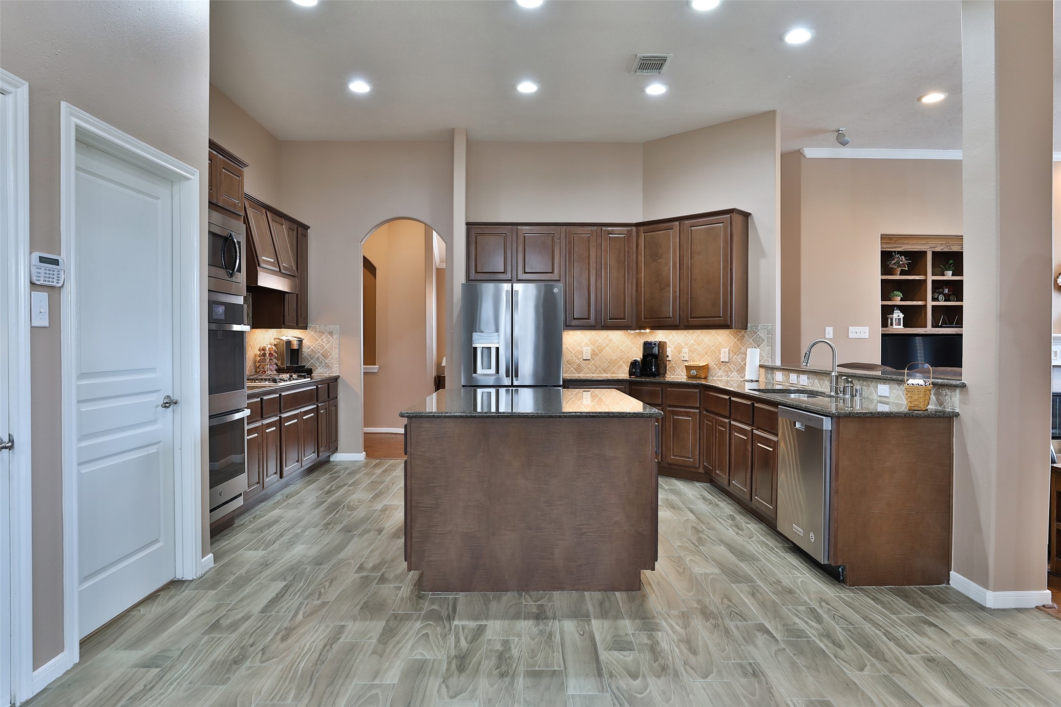20519 Windrose Bend Drive Spring, TX 77379 - Photo 11 of 37 Whether your the one cooking or the one who keeps the cook company, this kitchen is for you! Featuring an abundance of cabinetry and counter space. Equipped with premium stainless-steel GE appliances, including upgraded double ovens and a spacious island, this kitchen serves as the true heart of the home.