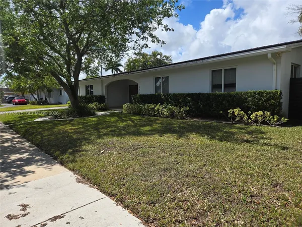 a front view of house with yard and trees