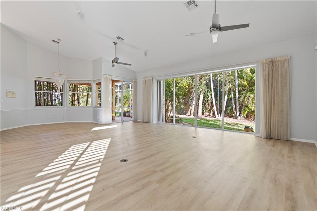 20751 Rivers Ford Estero, FL 33928 - Photo 19 of 36 Unfurnished living room with light wood-type flooring, ceiling fan, a chandelier, and high vaulted ceiling