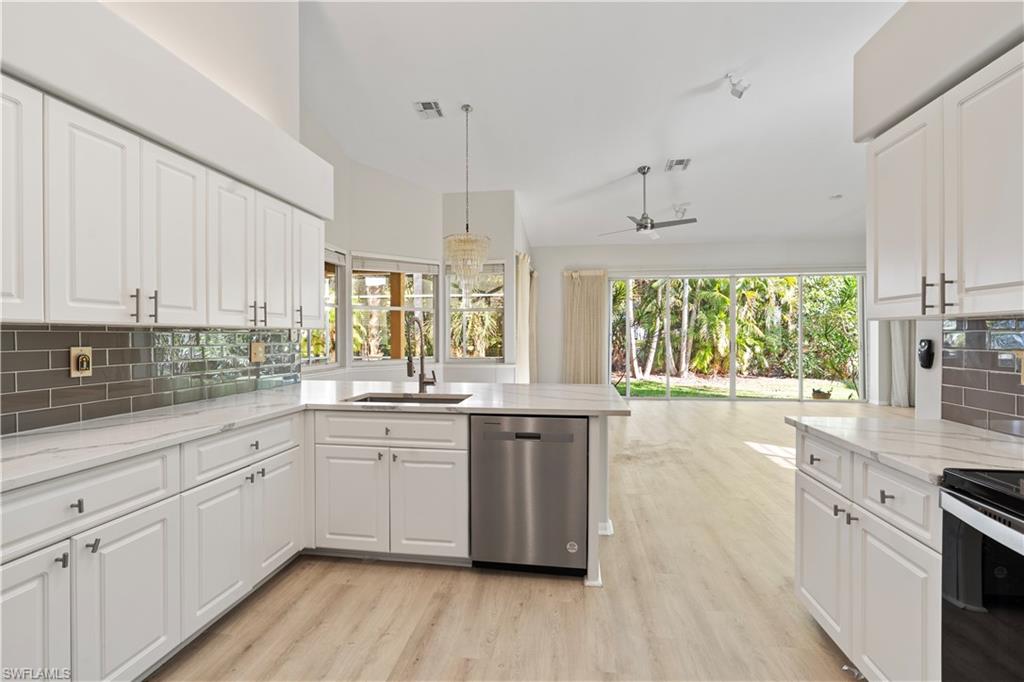 20751 Rivers Ford Estero, FL 33928 - Photo 5 of 36 Kitchen with tasteful backsplash, white cabinets, dishwasher, light stone counters, and vaulted ceiling