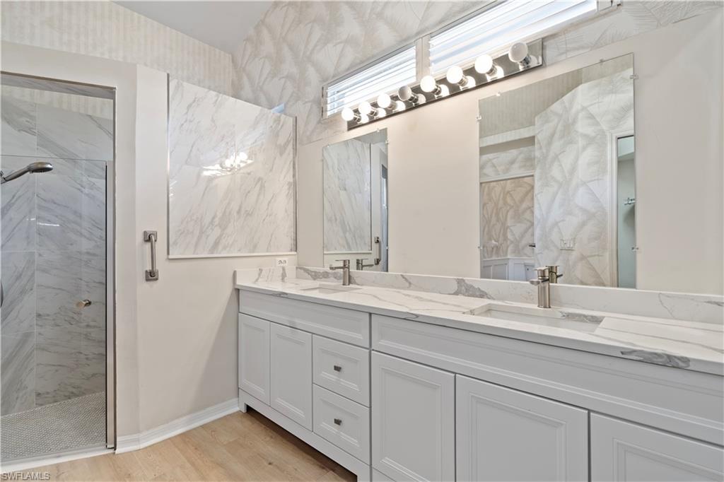 20751 Rivers Ford Estero, FL 33928 - Photo 8 of 36 Bathroom with a marble finish shower, double vanity, and light wood-type flooring