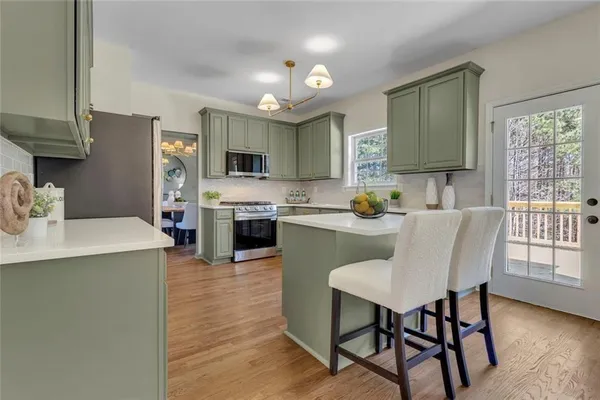 a kitchen with kitchen island a dining table and chairs