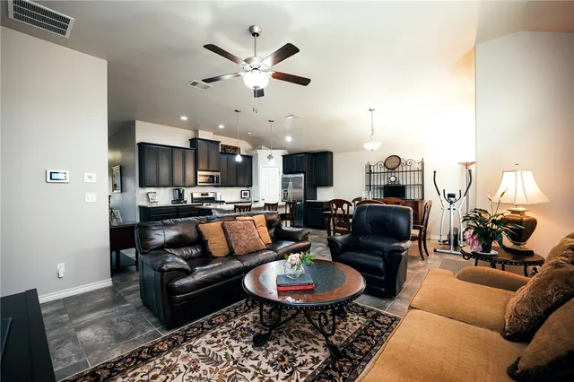 a living room with furniture kitchen and a chandelier